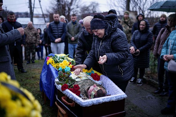 Natalia and Anatoliy Zhygunov cry at the coffin of their son Ruslan, a Ukrainian serviceman who was killed at the front line.