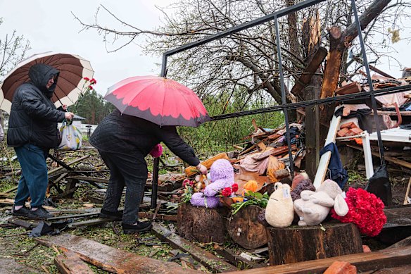Ukrainian women put flowers by the rubble of a destroyed house where three children were killed by a Russian strike in Korostyshiv, Zhytomyr region, in May.