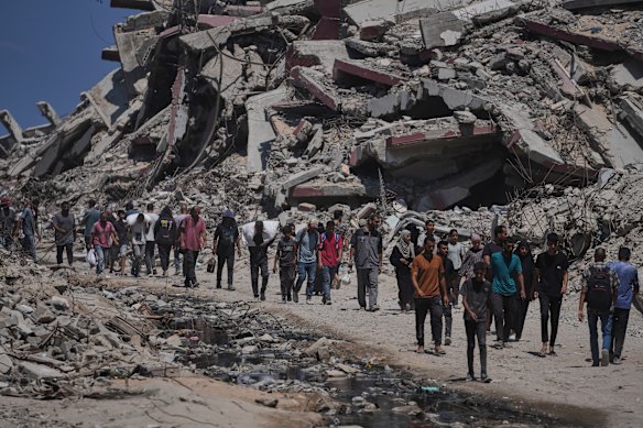 Palestinians carry sacks of humanitarian aid unloaded from trucks convoy that had been heading to Gaza City.