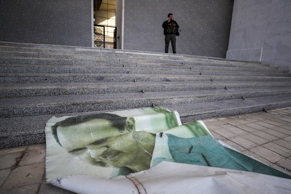 A giant picture of Syrian President Bashar Assad lies on the ground at his presidential palace in Damascus.