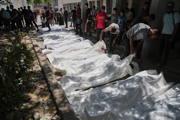 The bodies of Palestinians who were killed while attempting to access aid trucks entering northern Gaza are brought to a clinic in Gaza City on Sunday,