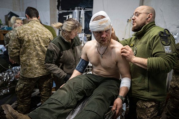A Ukrainian medic treats a wounded serviceman at a field hospital near Bakhmut. 