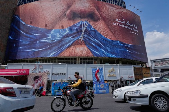 A billboard in downtown Tehran  with a graphic showing Donald Trump gagged by the Strait of Hormuz.
