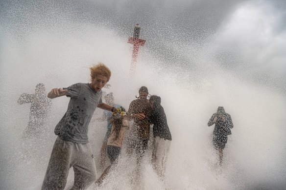 Spectators battered by waves at Brunswick Heads.