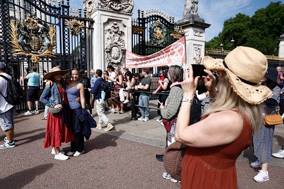 Tourists and demonstrators wait outside Buckingham Palace for Keir Starmer to arrive to officially resign.