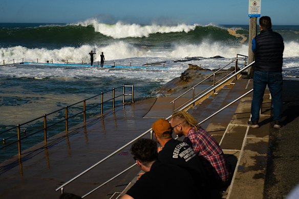 Crowds enjoy the spectacle at Dee Why baths.