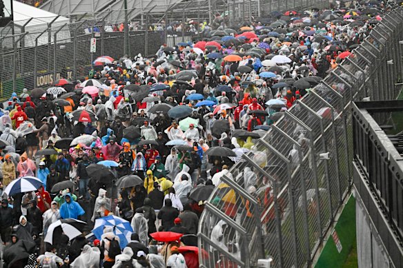F1 fans make their way out of the Albert Park circuit after enduring heavy rain for most of the day.