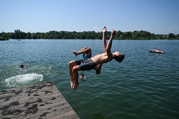 Kids jump off a pier on Bagry lake in Krakow.