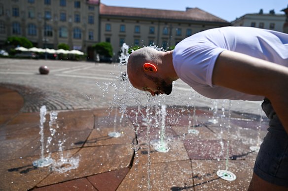 A man refreshes himself in a water fountain in Krakow, Poland.