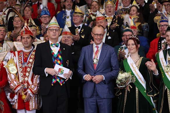 German Chancellor Friedrich Merz stands with carnival pairs representing carnival associations nationwide in Berlin, Germany.