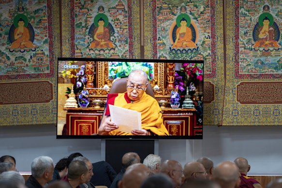 Buddhist monks watch a recorded video message from the Dalai Lama on Wednesday.