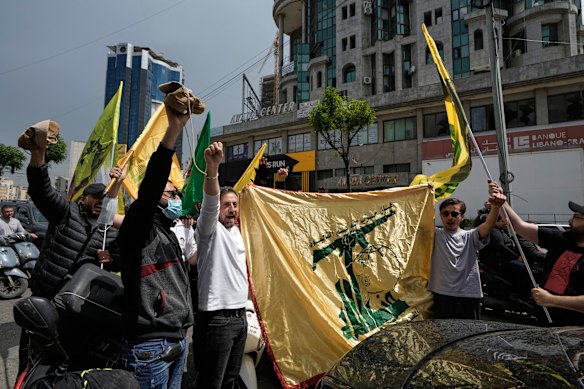 People chant slogans while holding Hezbollah flags in Beirut’s southern suburbs as the ceasefire begins.