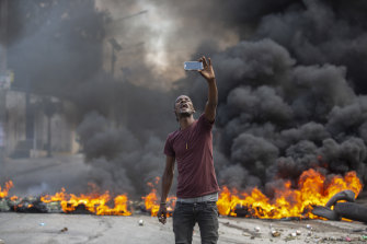 A protester takes a selfie at a burning barricade in Port-au-Prince, Haiti, on Monday.