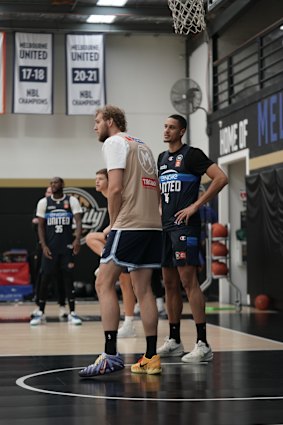 NBA centre Jock Landale (gold jersey) matches up with Melbourne United NBA import Jesse Edwards.