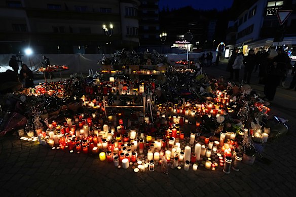 People light candles and place floral tributes outside the sealed-off Le Constellation bar.