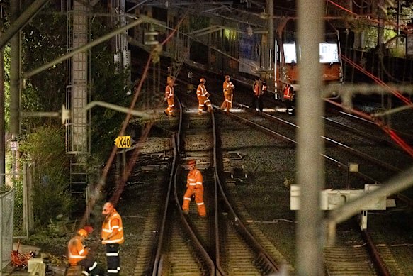 Workers on tracks near a stranded train at Homebush which crippled Sydney’s rail network for several days in May.