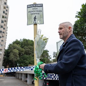 A local leaves flowers at the Waterloo unit block.