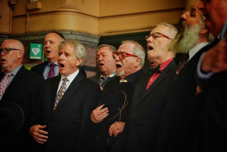 In full voice: Jason Fallscheer, back row at left, and fellow Men in Suits choir members.
