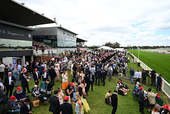 Crowds are seen on the front lawns after racegoers had to evacuate marquees because of wild winds during Geelong Cup.