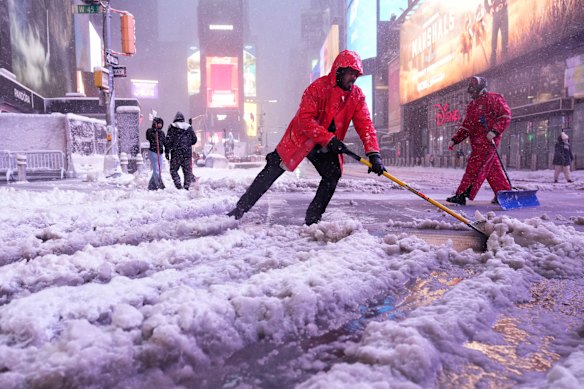 A worker shovels snow in Times Square on Monday.