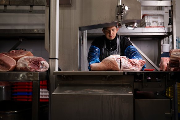 Wilmer Ropero cutting a pork leg for a osso buco at the Australian Meat Emporium. Meat that can be slow cooked until tender is in demand among increasingly an older clientele. 