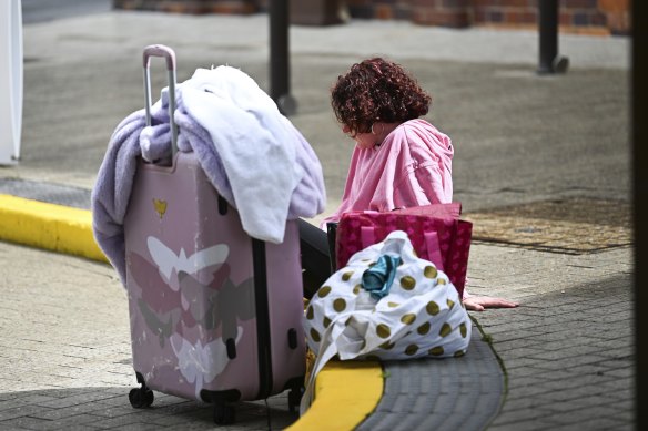 A woman sits outside a refuge centre in Brisbane, as the city prepared for the arrival of Cyclone Alfred.
