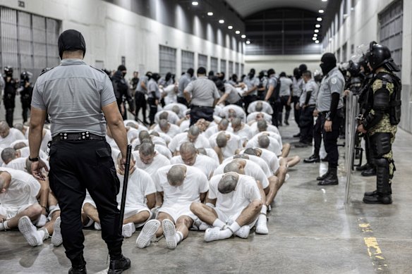 A prison guard transfers deportees from the US, alleged to be Venezuelan gang members, to the Terrorism Confinement Centre in Tecoluca, El Salvador.