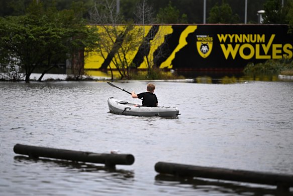 A boy kayaks in flood water in Tingalpa on Brisbane’s Eastside after ex-tropical Cyclone Alfred. While the floodwaters will subside, the mental toll of natural disasters remain.