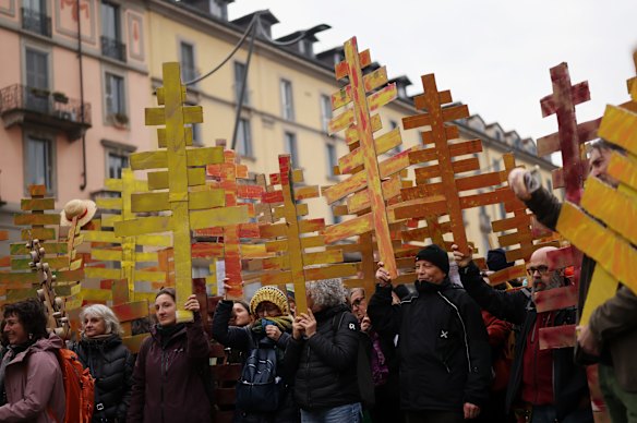 Protesters from the unsustainable Olympic committee hold carboard trees in Milan on Saturday.