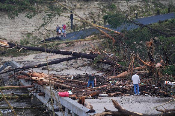 Debris sit on a bridge over the Guadalupe River after a flash flood swept through the area.