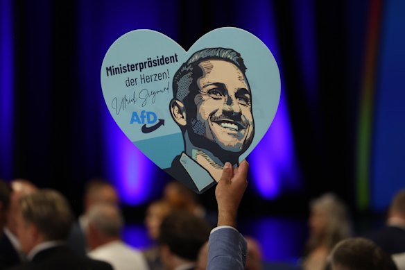 A supporter of the far-right Alternative for Germany (AfD) holds up a heart-shaped placard of Ulrich Siegmund.