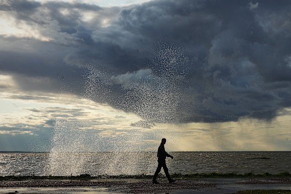 A man walks along the shore of the Gulf of Finland during a storm in St. Petersburg, Russia.