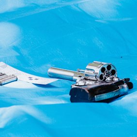 A handgun is photographed by police forensics outside a home on Kildare Road, Blacktown.