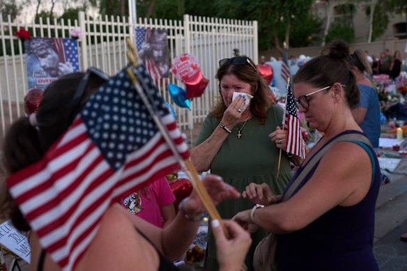 Patti Coleman wipes tears from her eyes at a memorial for Charlie Kirk in Phoenix, Arizona.
