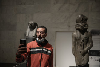 Un visiteur prend un selfie avec des statues pharaoniques à l'intérieur du nouveau Musée national de la civilisation égyptienne au Caire.  Le nouveau musée a ouvert ses portes avant le lancement d'une exposition de 22 momies royales qui étaient auparavant logées au musée égyptien près de la place Tahrir.