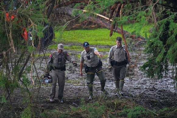 Officials inspect an area at Camp Mystic along the banks of the Guadalupe River in Hunt, Texas, on Sunday.