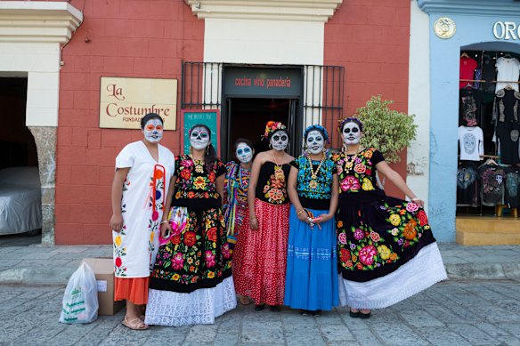 A group of women, with their faces painted for Mexico’s traditional Day of the Dead celebrations, gather on a street in the southern city of Oaxaca.
