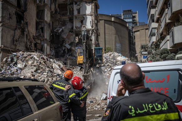 A bulldozer clears rubble from a Beirut building destroyed in an Israeli strike.