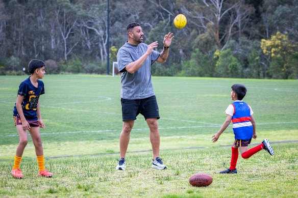 Balraj plays footy with his kids. 