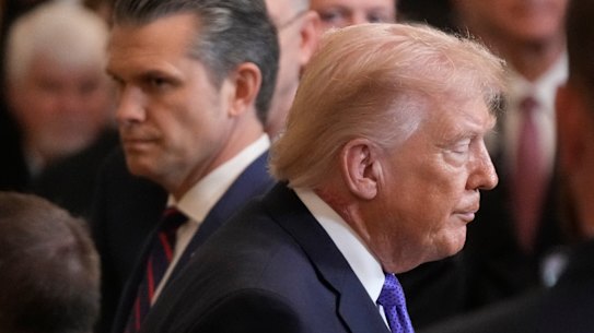 US President Donald Trump walks past War Secretary Pete Hegseth at the White House on Monday.