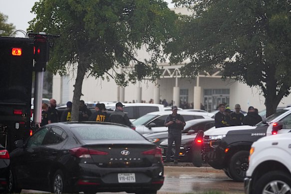 Law enforcement gather at a staging area close to a US Immigration and Customs Enforcement office after the shooting.
