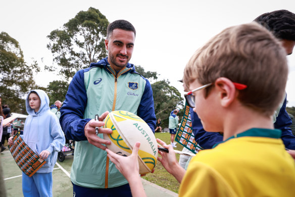 Wallabies prima  Tom Wright signs autographs astatine  a instrumentality   time  successful  Sydney. 