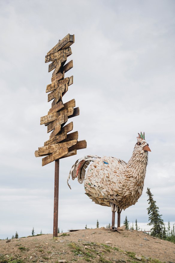 A poultry-themed wooden signpost and giant chicken in Chicken, Alaska.