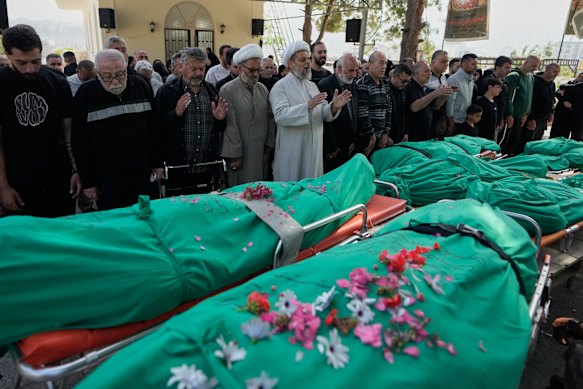 Men pray over the bodies of people killed in an Israeli airstrike in the village of Saksakieh, during a funeral procession in the southern port city of Sidon, south Lebanon, on Sunday.
