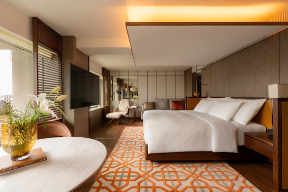 Open-plan rooms with warm walnut flooring and Peranakan-inspired accents.