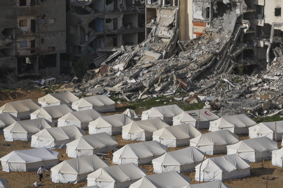 A tent camp for displaced Palestinians is set up next to destroyed buildings in Jabaliya, Gaza Strip.