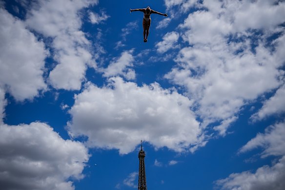 A diver in action during High Dive practice with the Eiffel Tower in the background at the European Aquatics Championships in Paris.