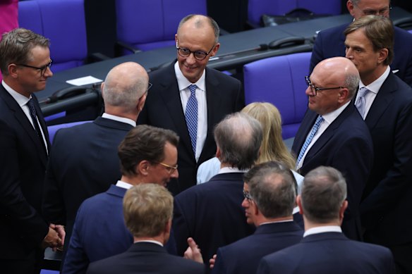 Friedrich Merz of the German Christian Democrats (CDU) is congratulated by colleagues after he won in a second vote in his election as German chancellor.