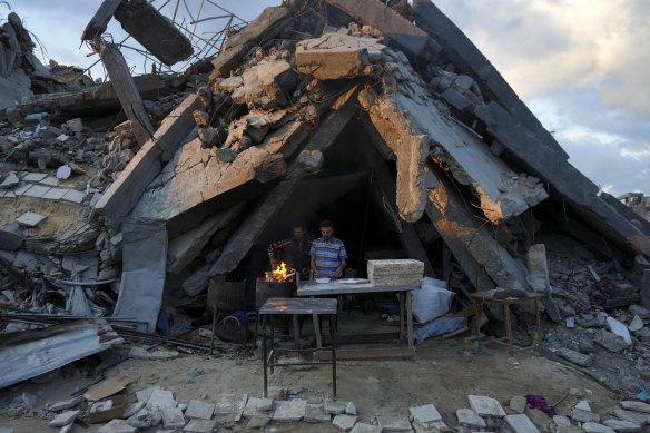 A man sells bread under the rubble of his Gaza bakery destroyed in an Israeli air raid.