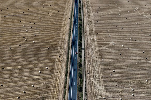 A car drives past straw bales on fields in the Taunus region near Frankfurt, Germany.